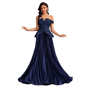Model in a peacock blue off-the-shoulder sequin formal gown with a fitted bodice, peplum waist, and flowing pleated skirt, front view.