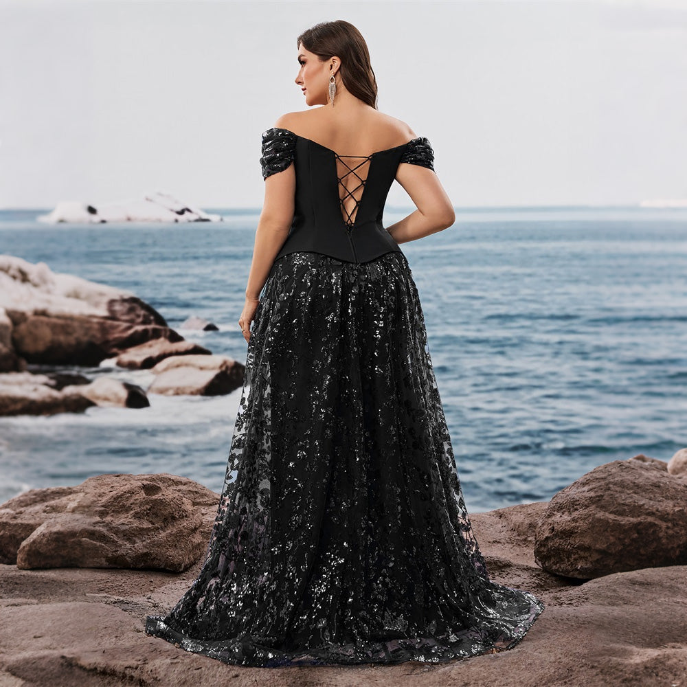Back view of an evening gown featuring a lace-up corset back and short puff sleeves, worn by a model on a beach. Elegant black dresses.