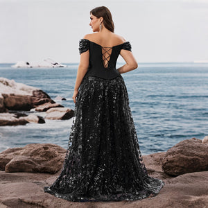 Back view of an evening gown featuring a lace-up corset back and short puff sleeves, worn by a model on a beach. Elegant black dresses.