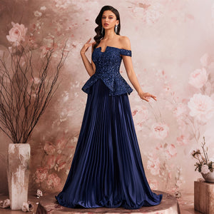 Full length view of a navy blue A-line evening gown featuring a fitted sequin bodice and a flowing pleated skirt, styled in a romantic event setting.